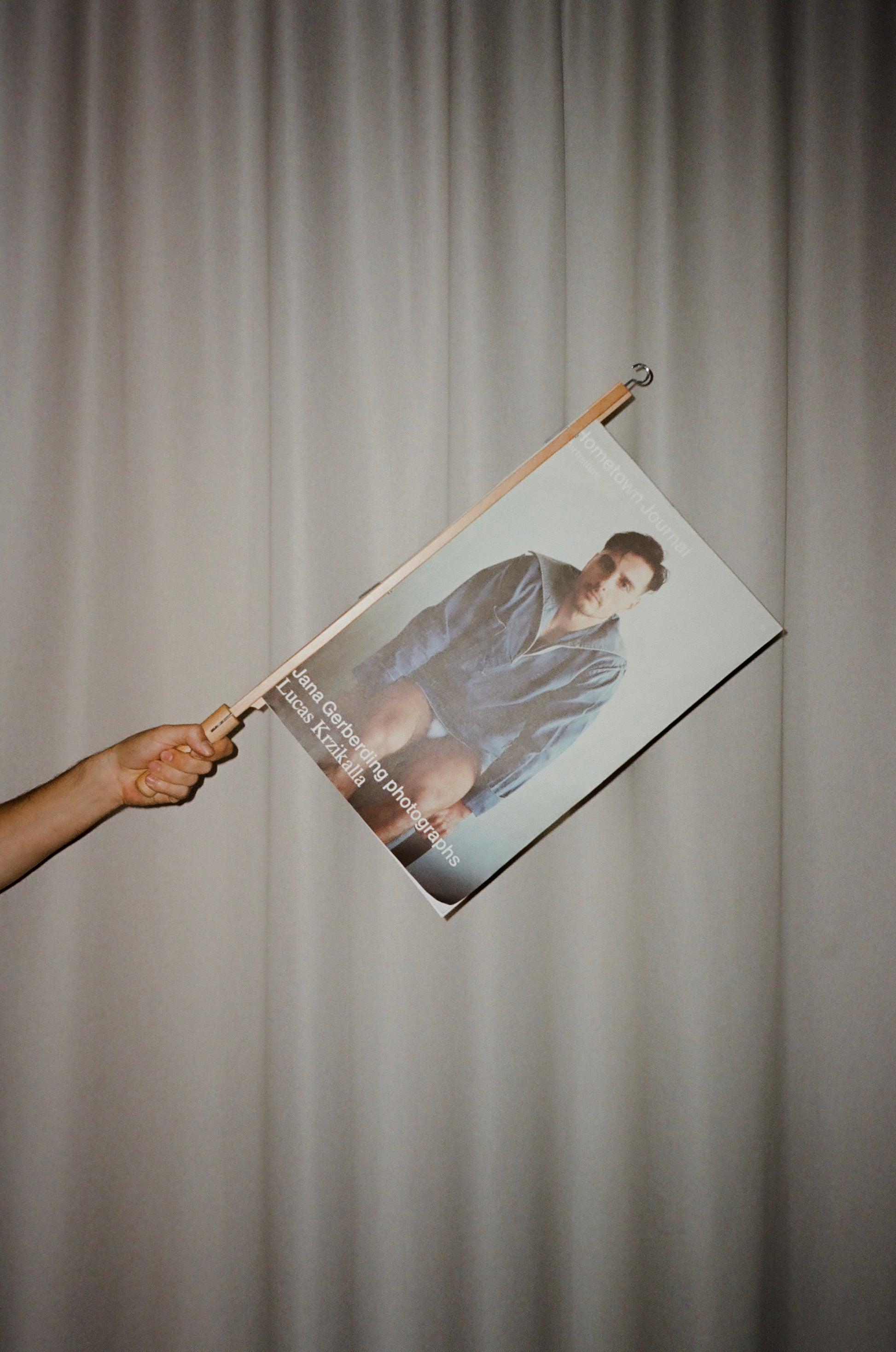 Person holding a Magazinecover of a person like a Flag against a plain background