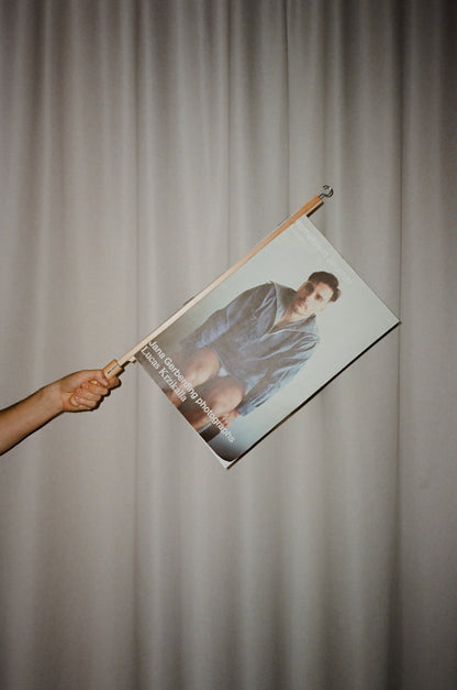 Person holding a Magazinecover of a person like a Flag against a plain background